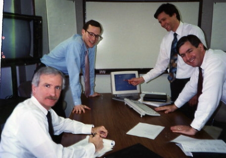 Advantage Computing Systems Business Analysts gathered around a table