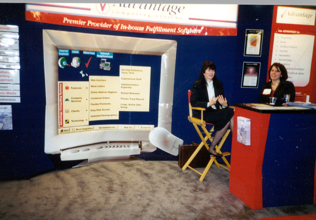 Sales team members smile from their trade show booth