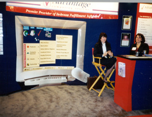 Sales team members smile from their trade show booth